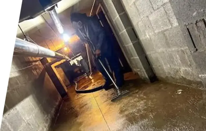 Technician extracting water in a block-wall basement in Manchester
