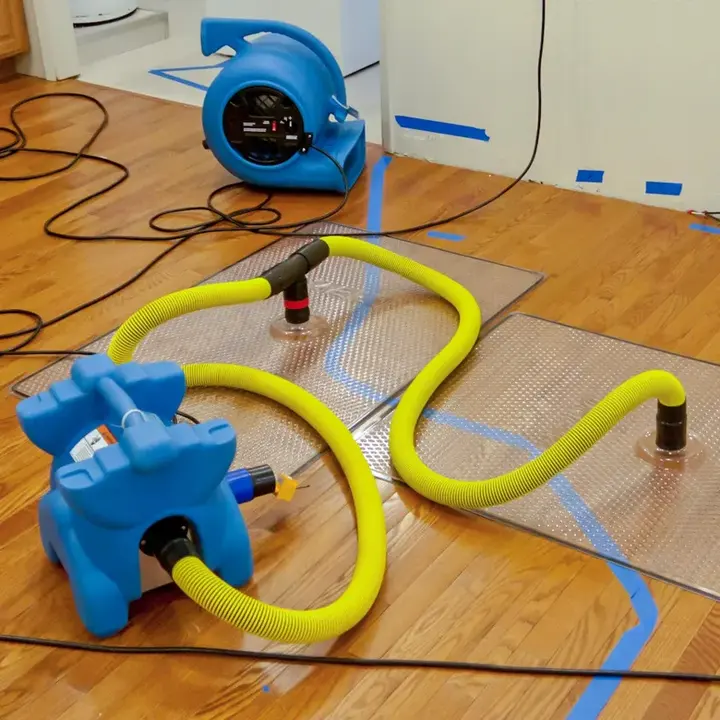 Air mover and floor drying mats set on hardwood in Manchester