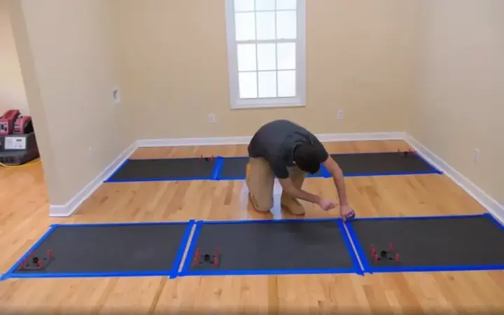 Technician setting hardwood floor drying mats in a Manchester home