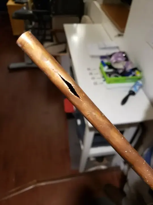 Copper supply line split open after a burst pipe in Manchester