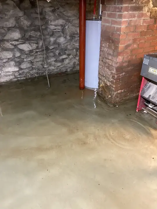 Groundwater across the floor of an old stone and brick basement in Manchester
